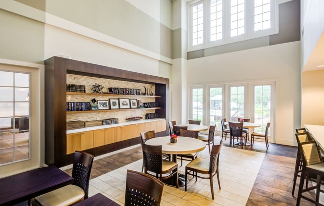 a dining room with tables and chairs and a large window