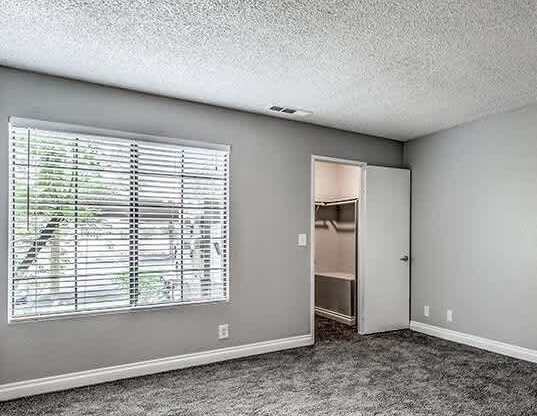 A room with a window and a door leading to another room.