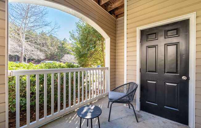 A black door is on the right side of a white fence.