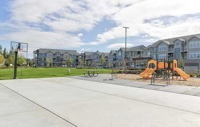 Olympia, WA Apartments for Rent- Briggs Village- Outdoor Basketball Court Adjacent to Playground Surrounded by Greenery