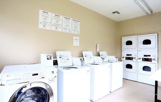 a laundry room filled with lots of coin washing machines