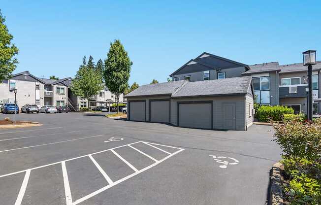 A parking lot with garages in the background and a clear blue sky at The Landing Apartments and Townhomes, Oregon, 97045