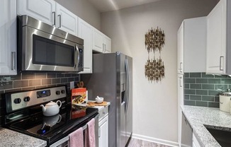 a kitchen with a stainless steel refrigerator and microwave