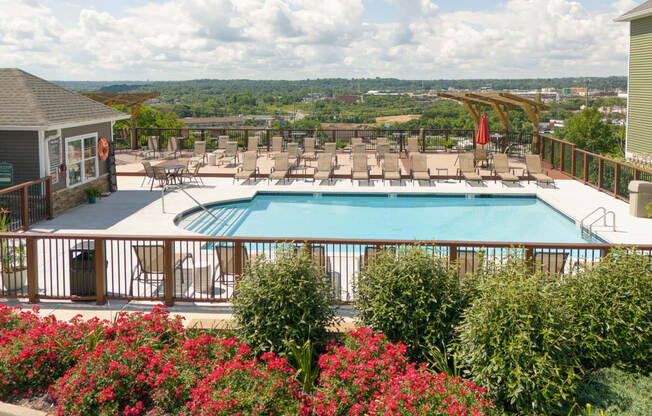 a swimming pool with lounge chairs and a deck with a resort style pool