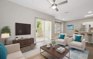 A living room with a white couch, a wooden coffee table, and a flat screen TV.