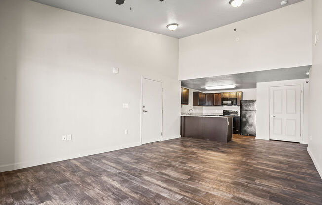 the living room and kitchen of a new home with white walls and wood flooring