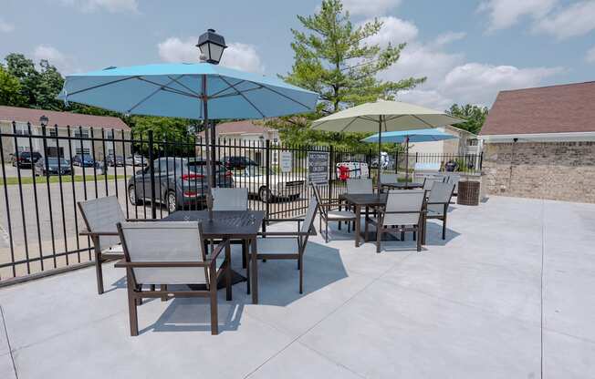 a patio with tables and chairs and umbrellas
