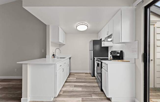 A modern kitchen with white cabinets and appliances.
