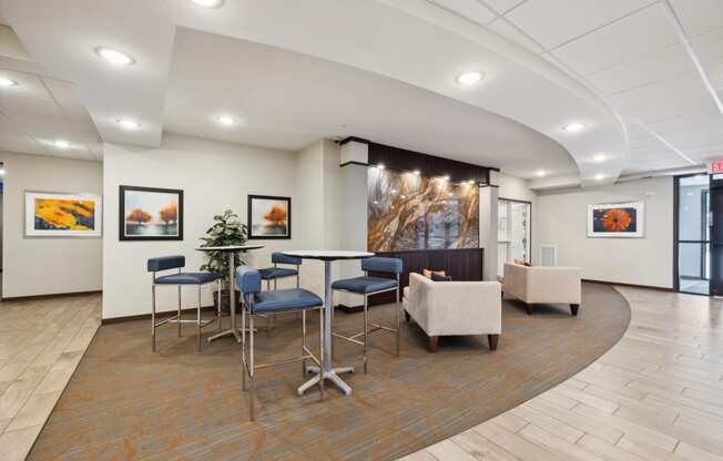 a communal area with tables and chairs in the lobby of a building