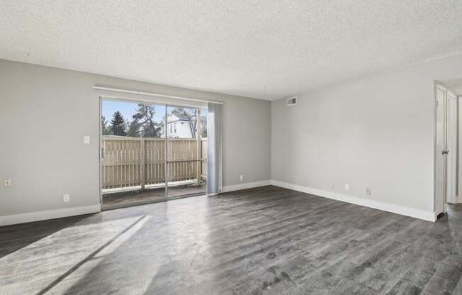 A room with a sliding glass door leading to a backyard.