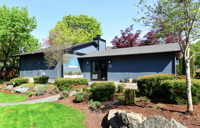 a blue building with a landscaped garden in front of it