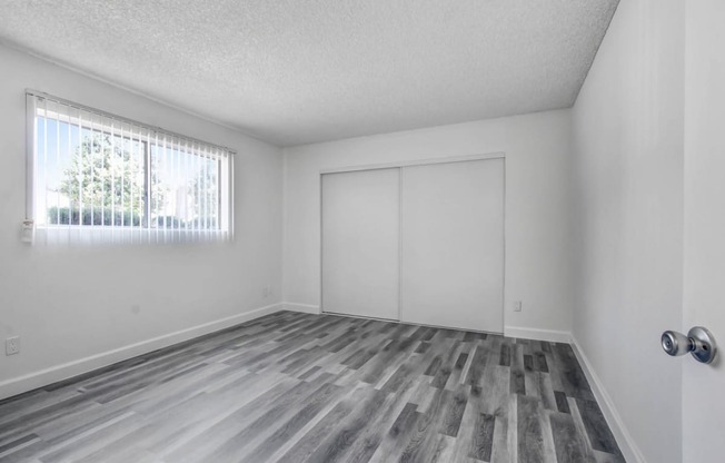 a bedroom with white walls and a window