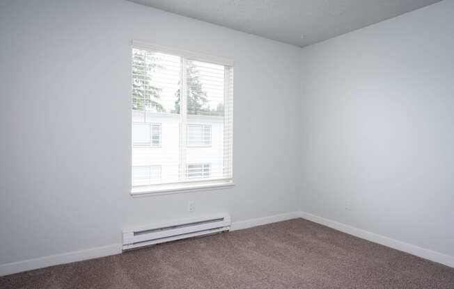 an empty room with white walls and a window