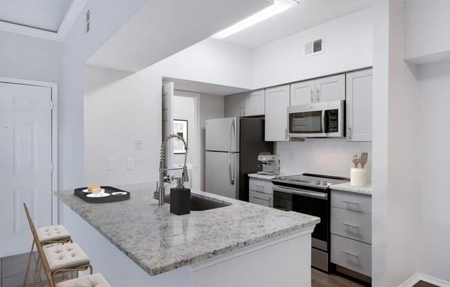 a kitchen with white cabinets and a granite counter top