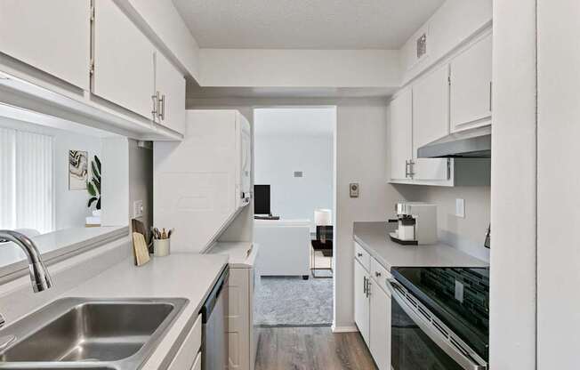 A modern kitchen with white cabinets and stainless steel appliances.