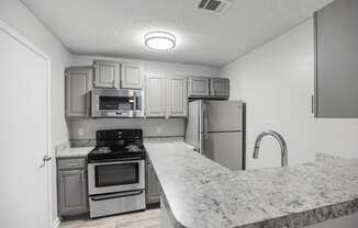 a kitchen with granite counter tops and stainless steel appliances