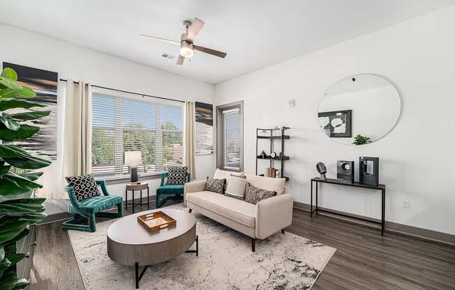 A living room with a white couch, a coffee table, and a ceiling fan.