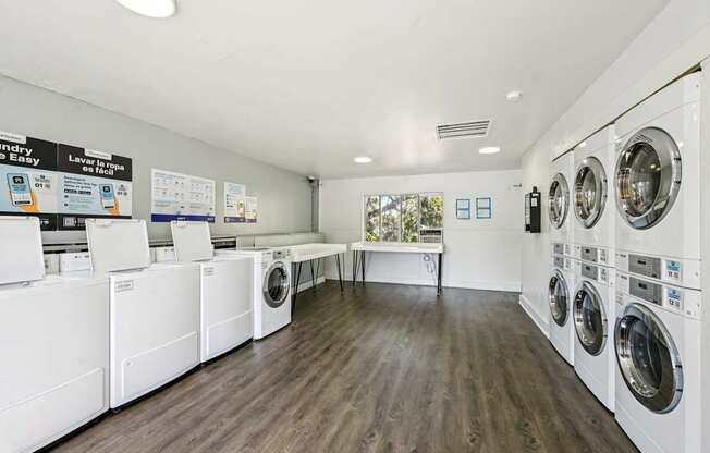 A laundry room with washing machines and a sign that says "Laundry Easy".