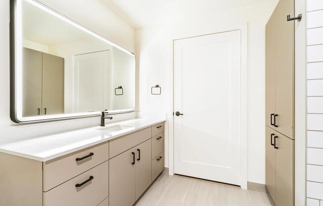 Modern bathrooms feature quartz countertops, illuminated mirrors, contemporary black fixtures, and built-in storage solutions that maximize both style and functionality.