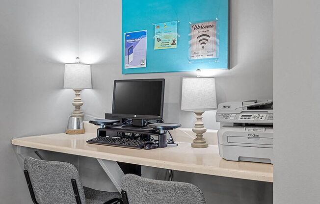 an office with a computer and printer on a desk