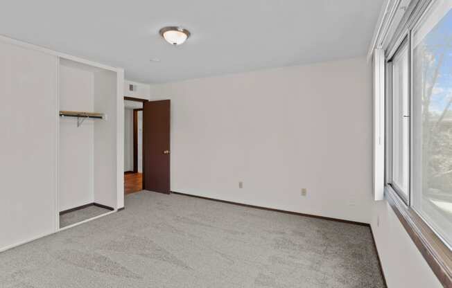 a bedroom with a large window and a closet