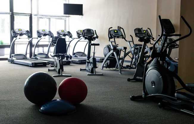 a gym with treadmills and exercise balls at Hampton Plaza Apartments in Towson, MD 21286
