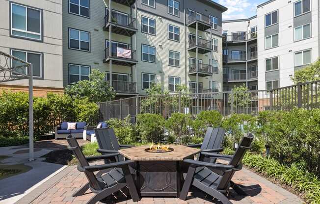 an outdoor patio with a firepit and four chairs