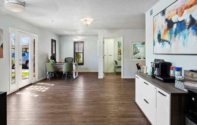 A living room with a dining area and kitchenette.