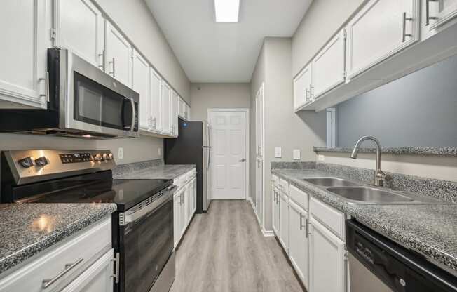 a kitchen with white cabinets and stainless appliances