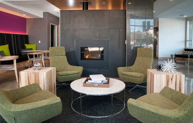 A sitting room with a fireplace and green chairs.