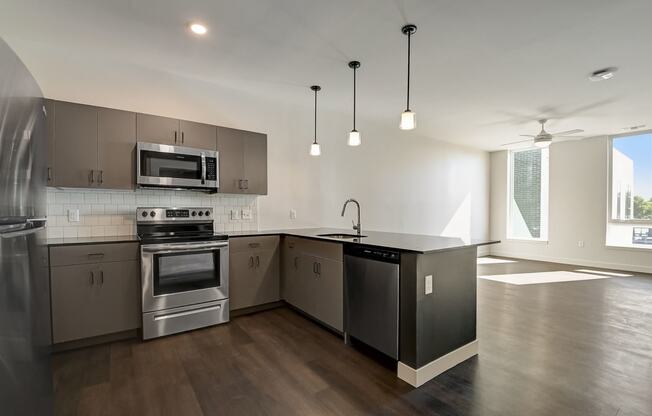 a kitchen with stainless steel appliances and an island with a black countertop