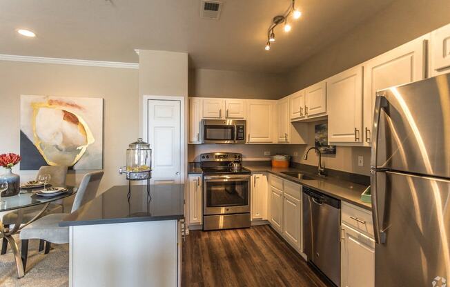 a kitchen with stainless steel appliances and a dining room table