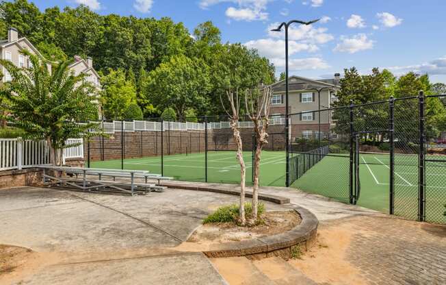 a tennis court with a fence around it and some trees