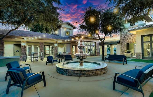 A beautifully lit patio with a fountain at the center.