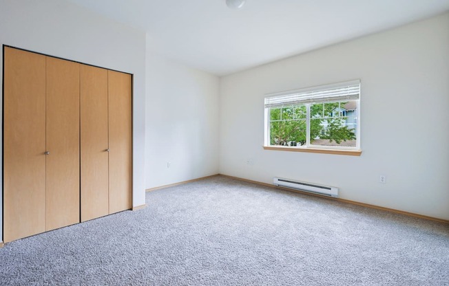 Soho bedroom with a window and a carpeted floor at Abbey Rowe Apartments in Olympia, WA