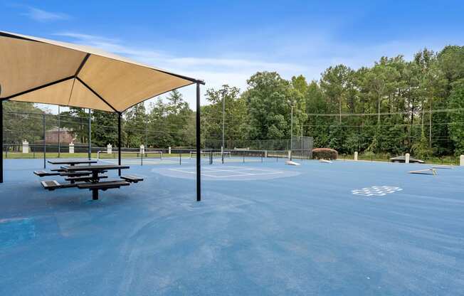 the basketball court at the park has picnic tables on it