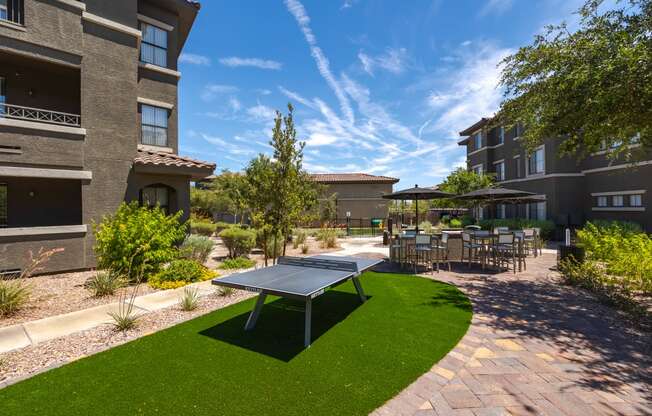 a ping pong table sits in the middle of a grassy area in front of a