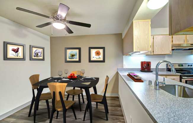 a dining room table with chairs next to a kitchen