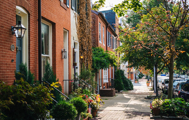 a city street with brick buildings and potted plants