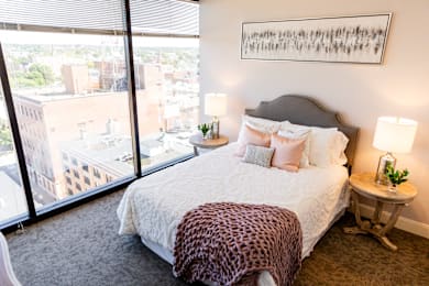 a bedroom with a large window and a leopard print bedspread