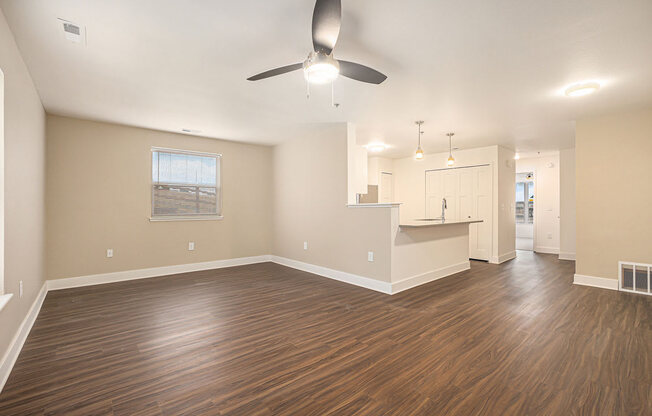 Enlarged living room and kitchen with a ceiling fan  at Signature Pointe Apartment Homes, Alabama, 35611