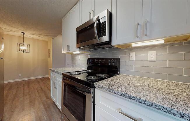 A kitchen with a black microwave above the stove. at Vue on Medlock, Peachtree Corners, GA, 30092
