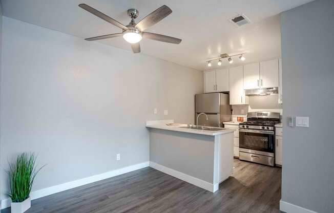 an open kitchen and living room with a ceiling fan