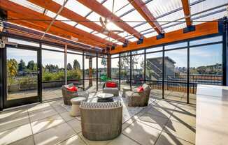The Hayes on Stone Way Apartments patio with wicker chairs and a glass roof at The Hayes on Stone Way, Seattle, WA, 98103