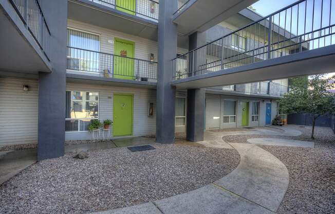 the courtyard of a building with two balconies and a green door