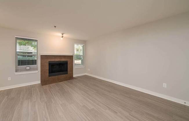 A room with a fireplace and wood flooring.
