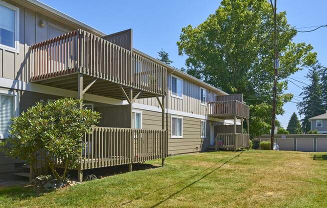 the back of two houses with balconies and a grass yard at Woodhaven, Washington, 98203