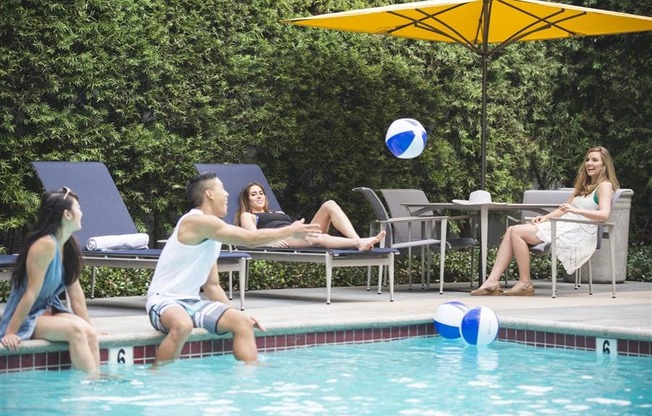 Pool with people playing with beach ball at Wilshire Vermont, Los Angeles, 90010