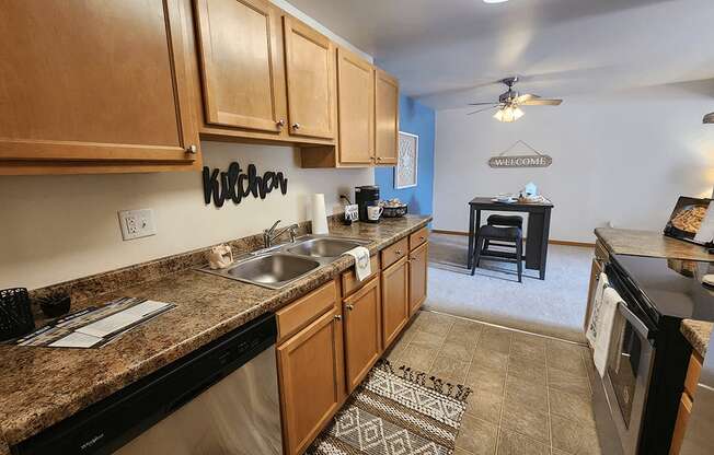 A kitchen with wooden cabinets and a black dishwasher.
