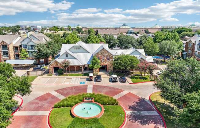 an aerial view of a courtyard with a pool and a building with trees